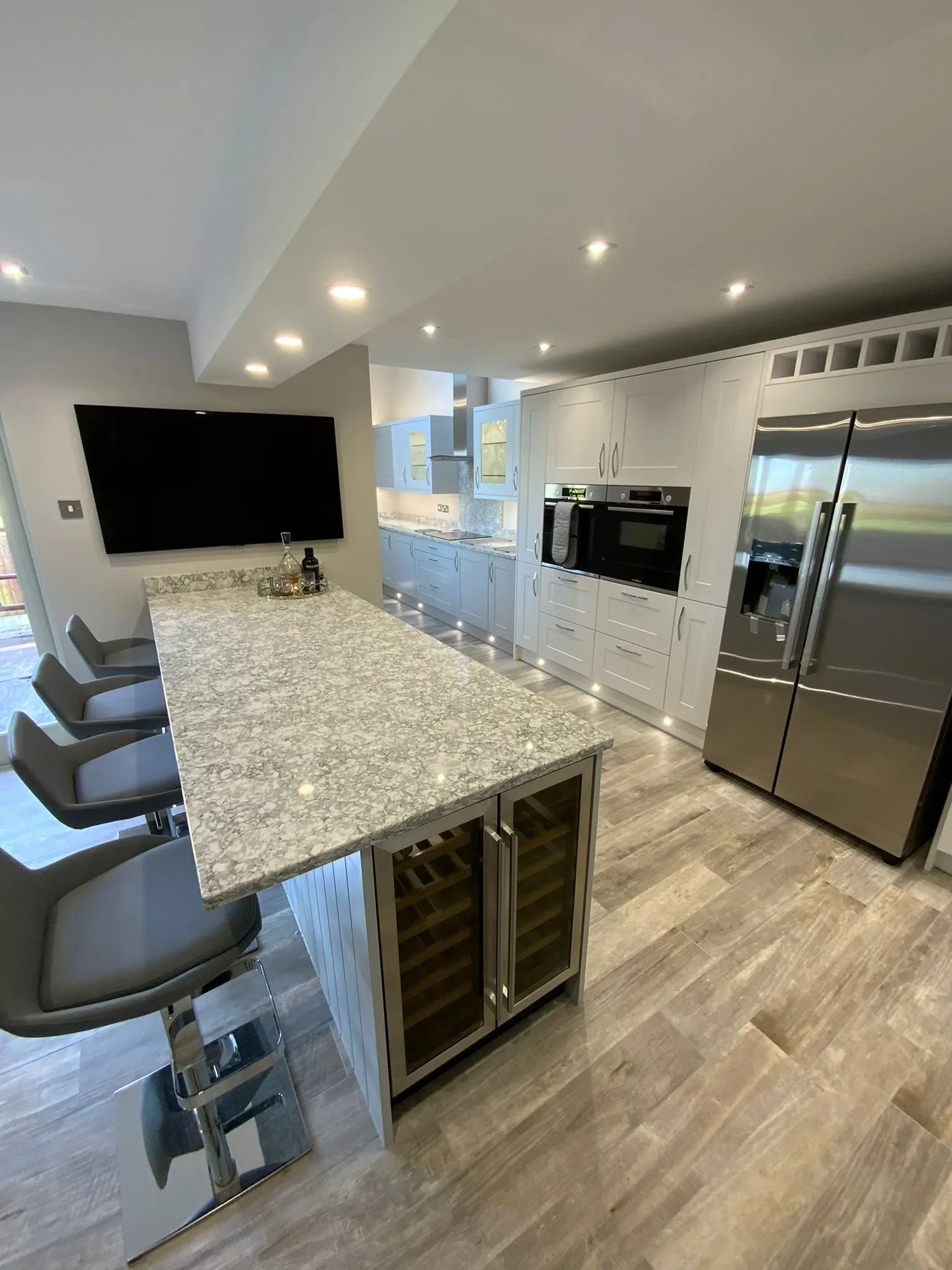 Bespoke grey hand-painted shaker kitchen with granite-topped island and integrated wine cooler