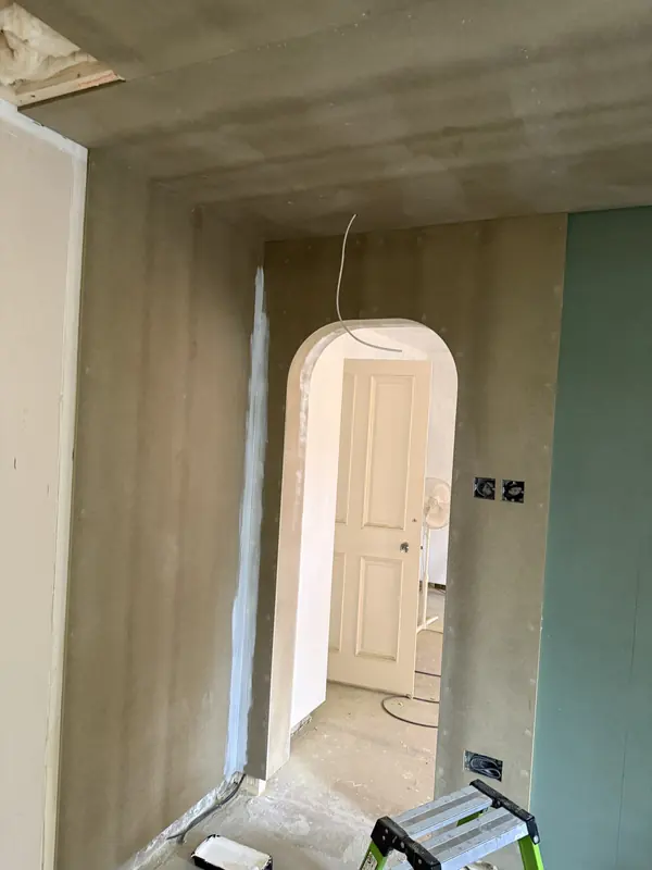 A boarded arched doorway with a crisp curved edge, before decoration