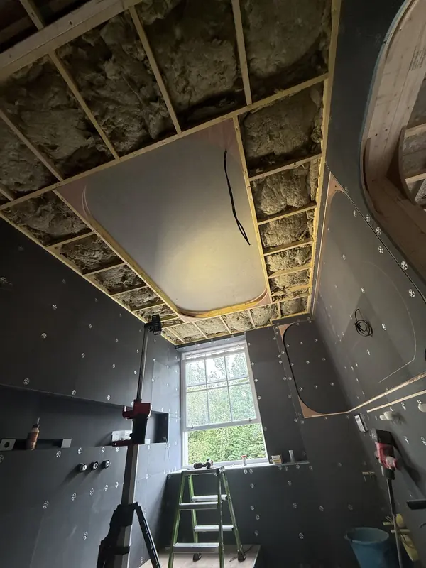 Rounded ceiling coffer framed in timber and plywood above a tanked en-suite