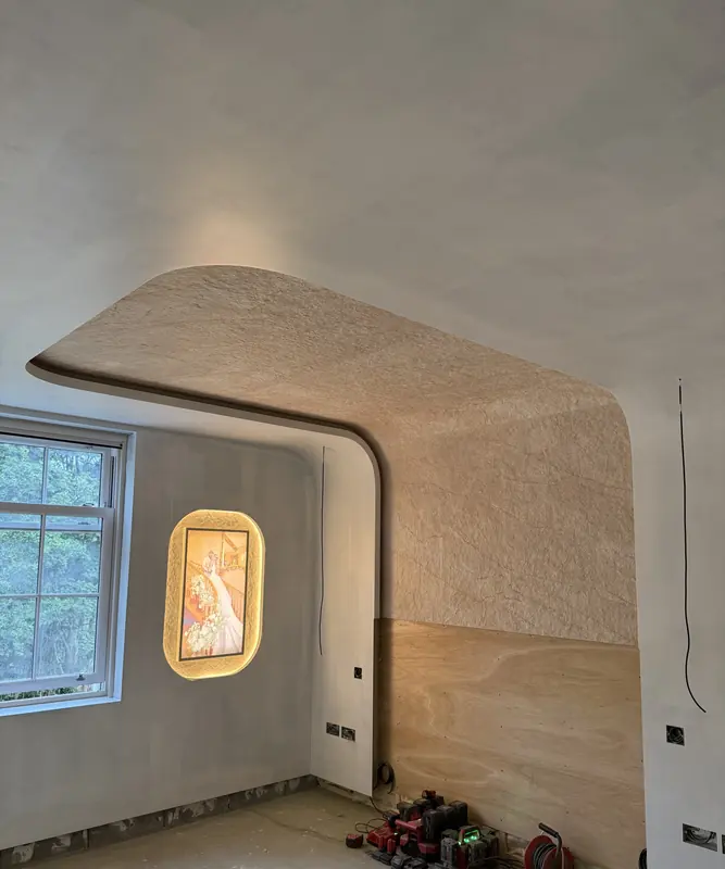 Curved coffered ceiling and lit art niche in the master bedroom