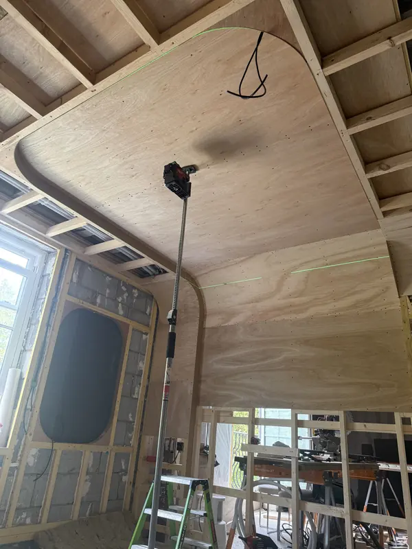 Plywood-skinned ceiling with a radiused edge, checked with a laser on a pole