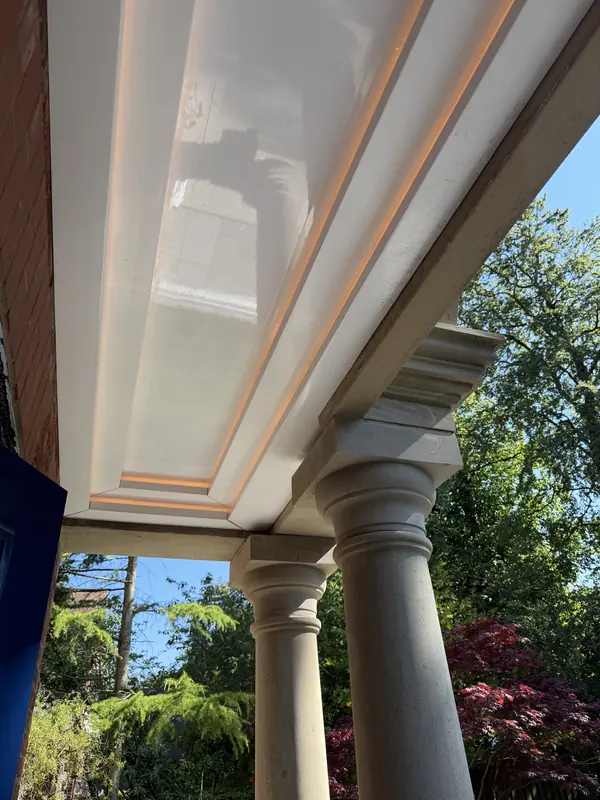 Stepped soffit with concealed LED lighting above a stone colonnade