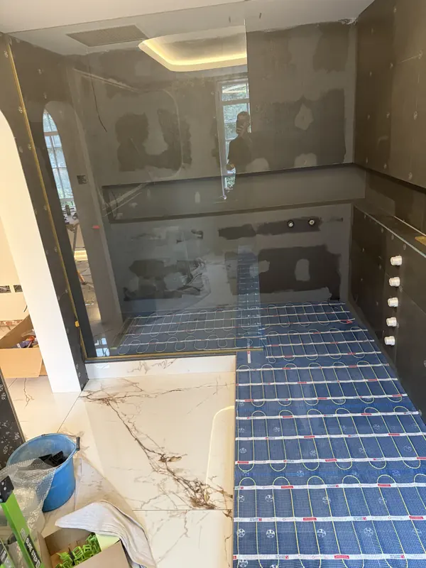 Electric underfloor heating mats beside freshly laid large-format tiles