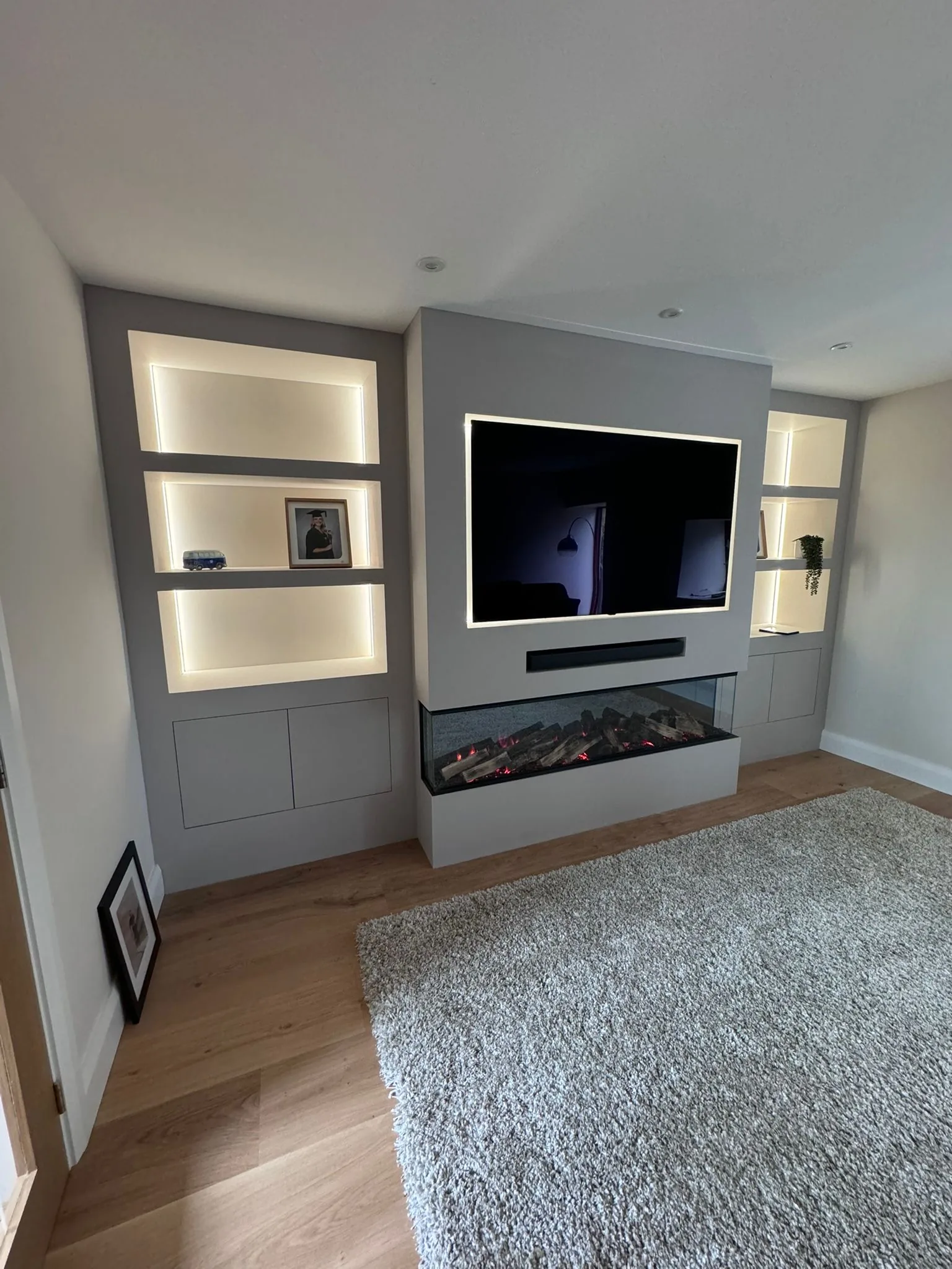 Bespoke painted media wall with integrated fire and illuminated display niches