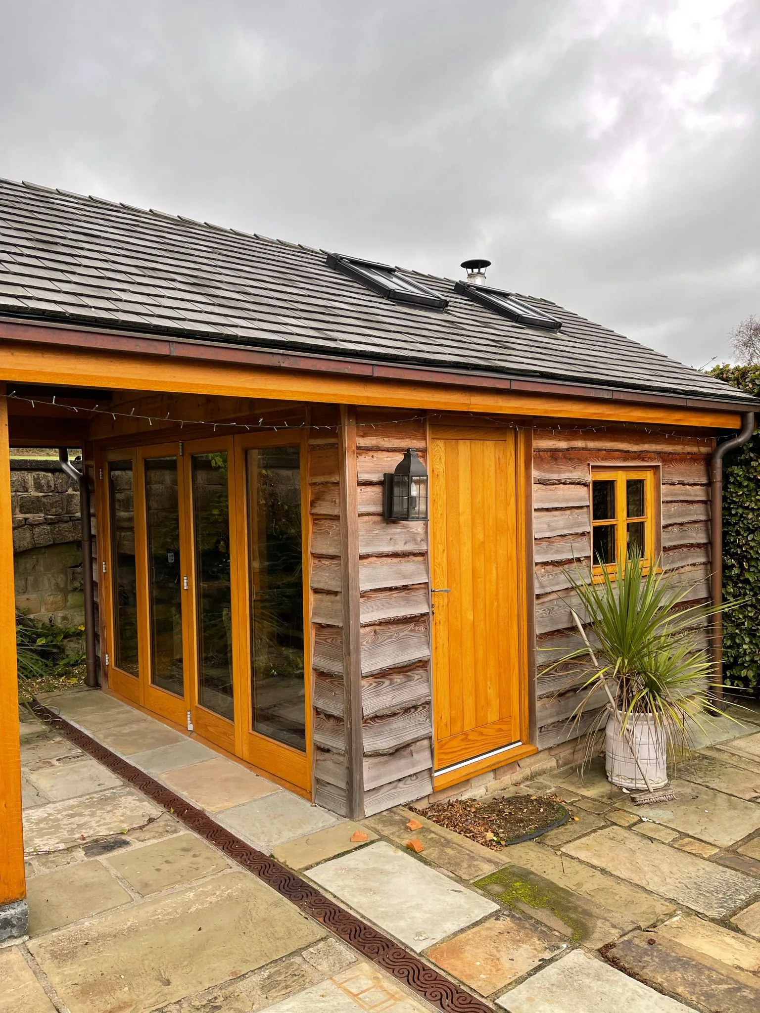 Bespoke oak-frame garden cabin with waney-edge cedar cladding and slate roof