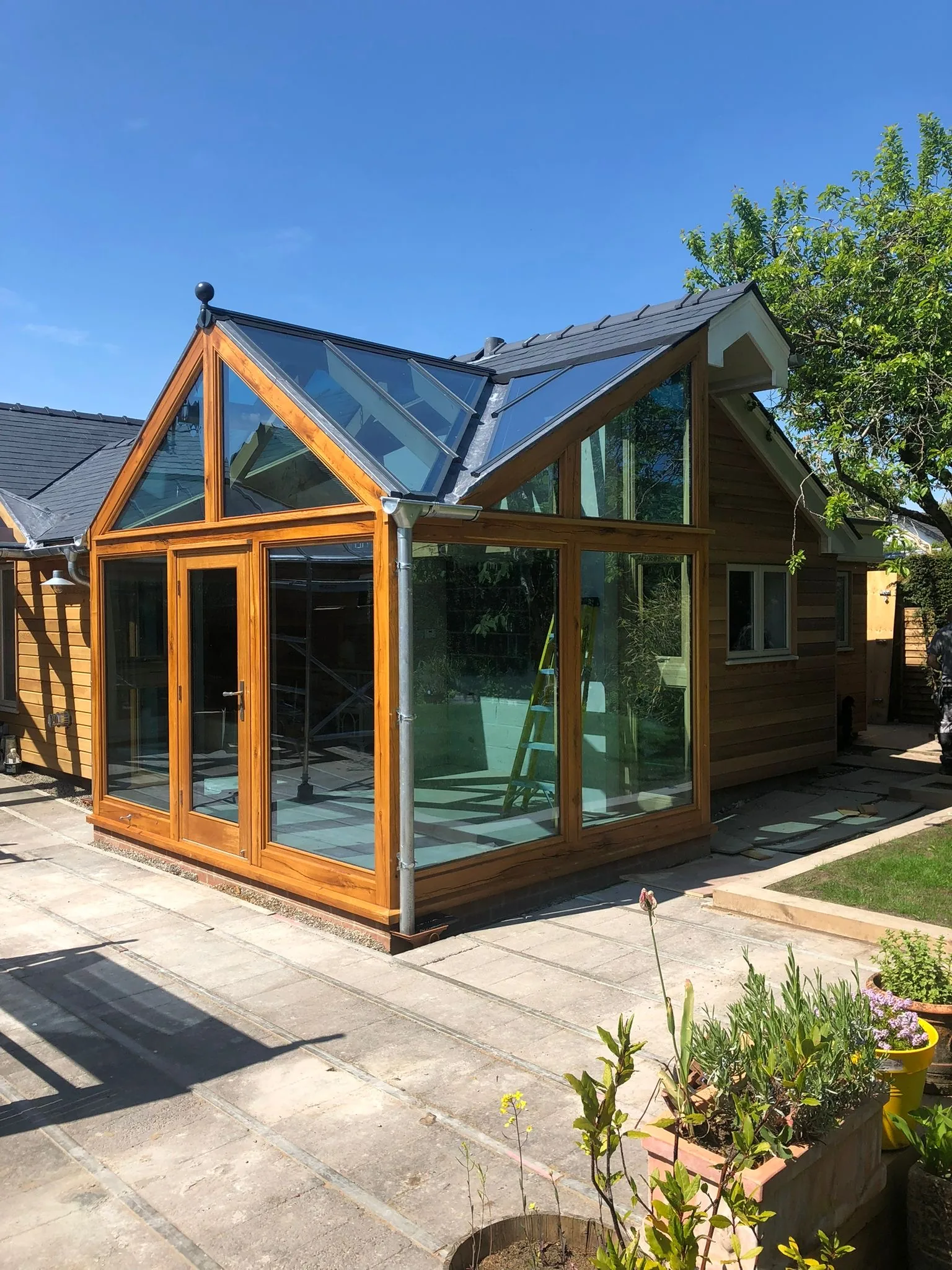 Bespoke oak-frame glazed garden room with steeply pitched glass gables