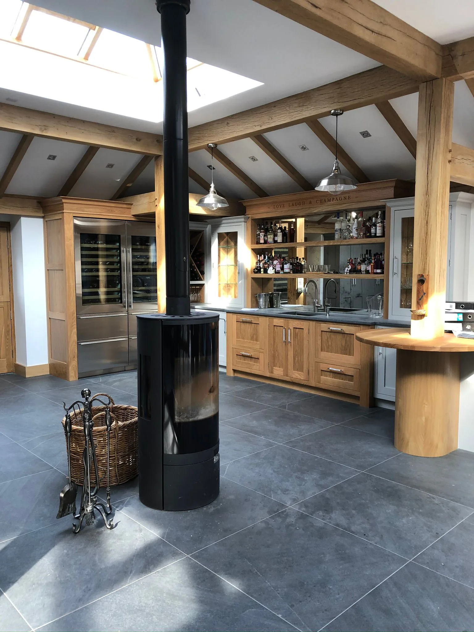Oak-frame kitchen with mirrored champagne bar and central wood-burning stove