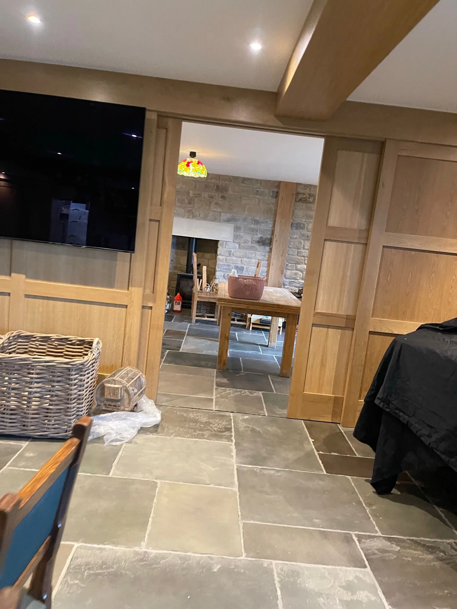 Bespoke oak wall panelling with concealed sliding doors, illustrating the fitted-joinery craft we bring to luxury bedrooms and dressing rooms
