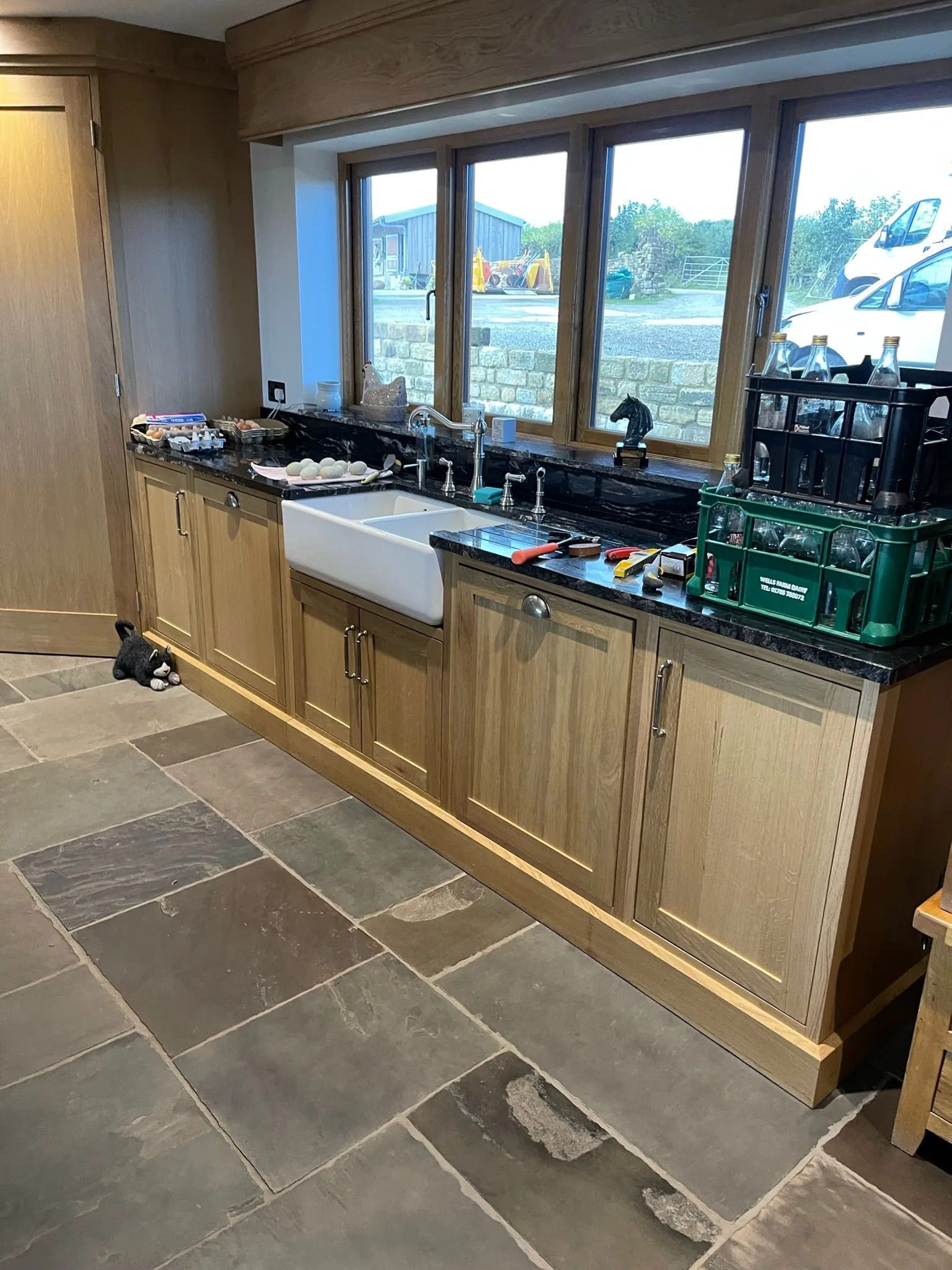 Bespoke oak shaker kitchen with Belfast sink, granite worktop, and flagstone floor