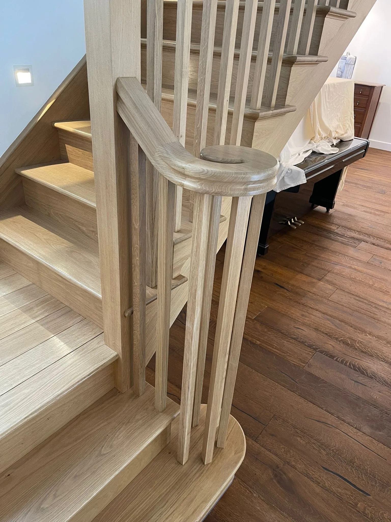 Hand-shaped oak staircase volute and turned spindles, traditional craftsmanship by Joinery Limited