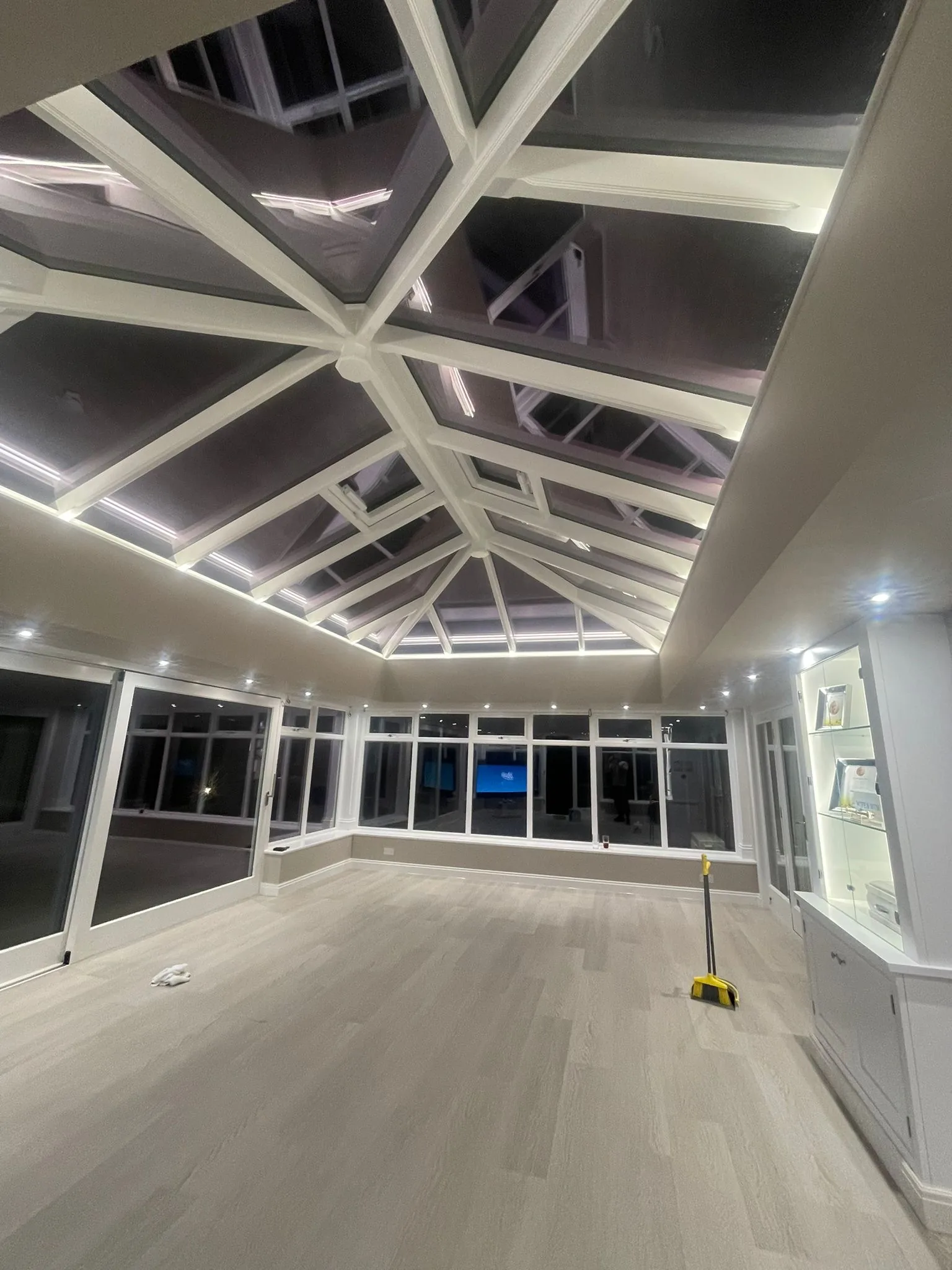 Bespoke painted timber orangery with coffered lantern roof, photographed at night