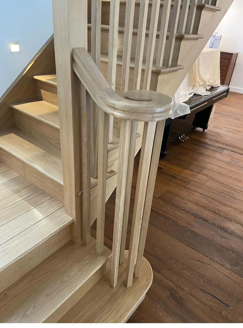 Bespoke oak staircase detail with hand-turned newel and curved handrail