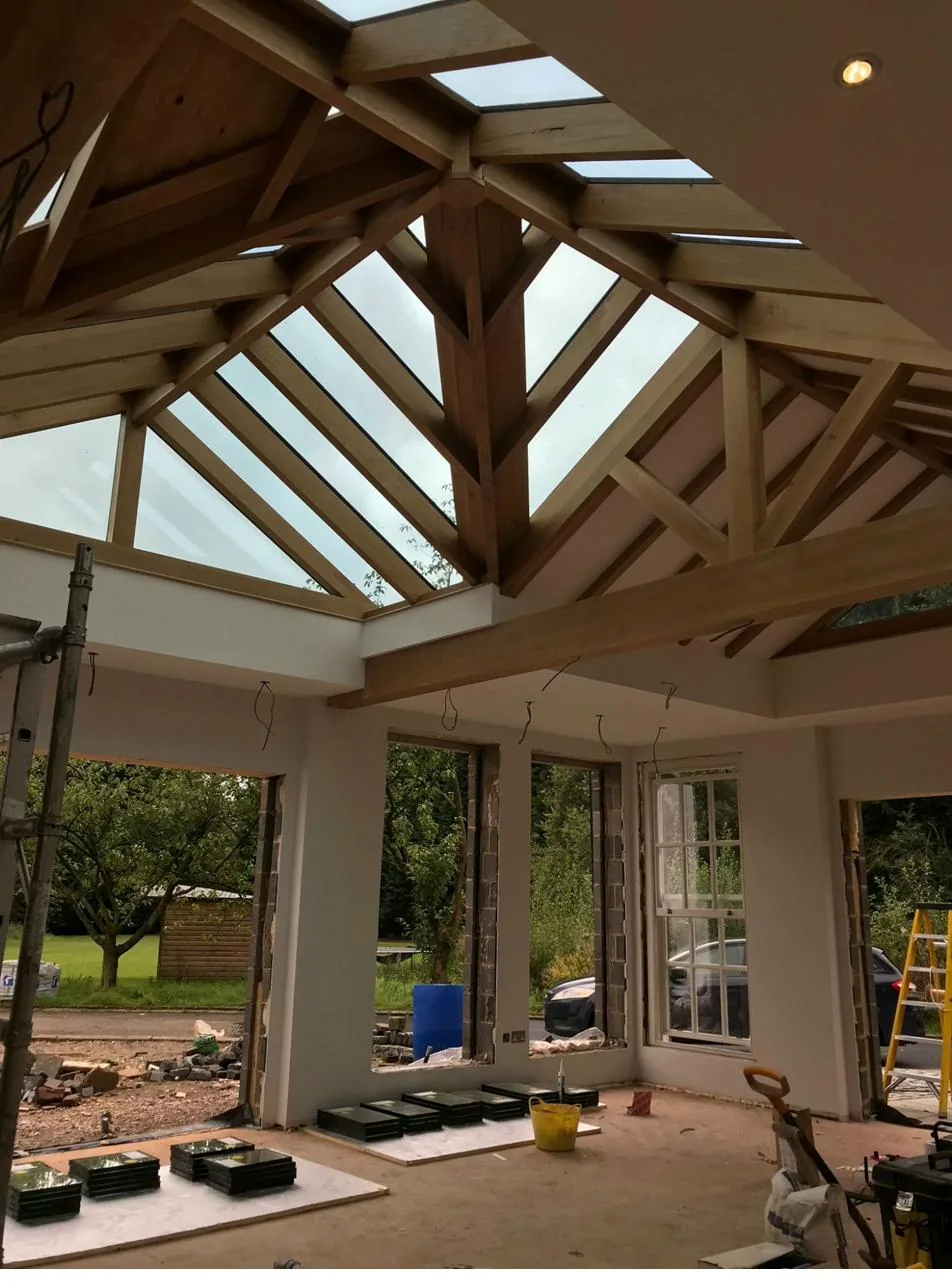 Oak-framed orangery during structural build, showing exposed timber roof