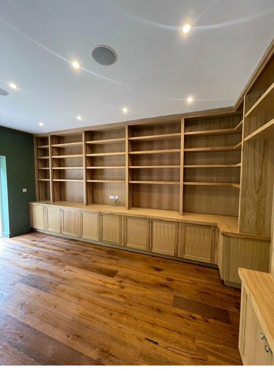 Bespoke oak library with floor-to-ceiling fitted shelving by Joinery Limited