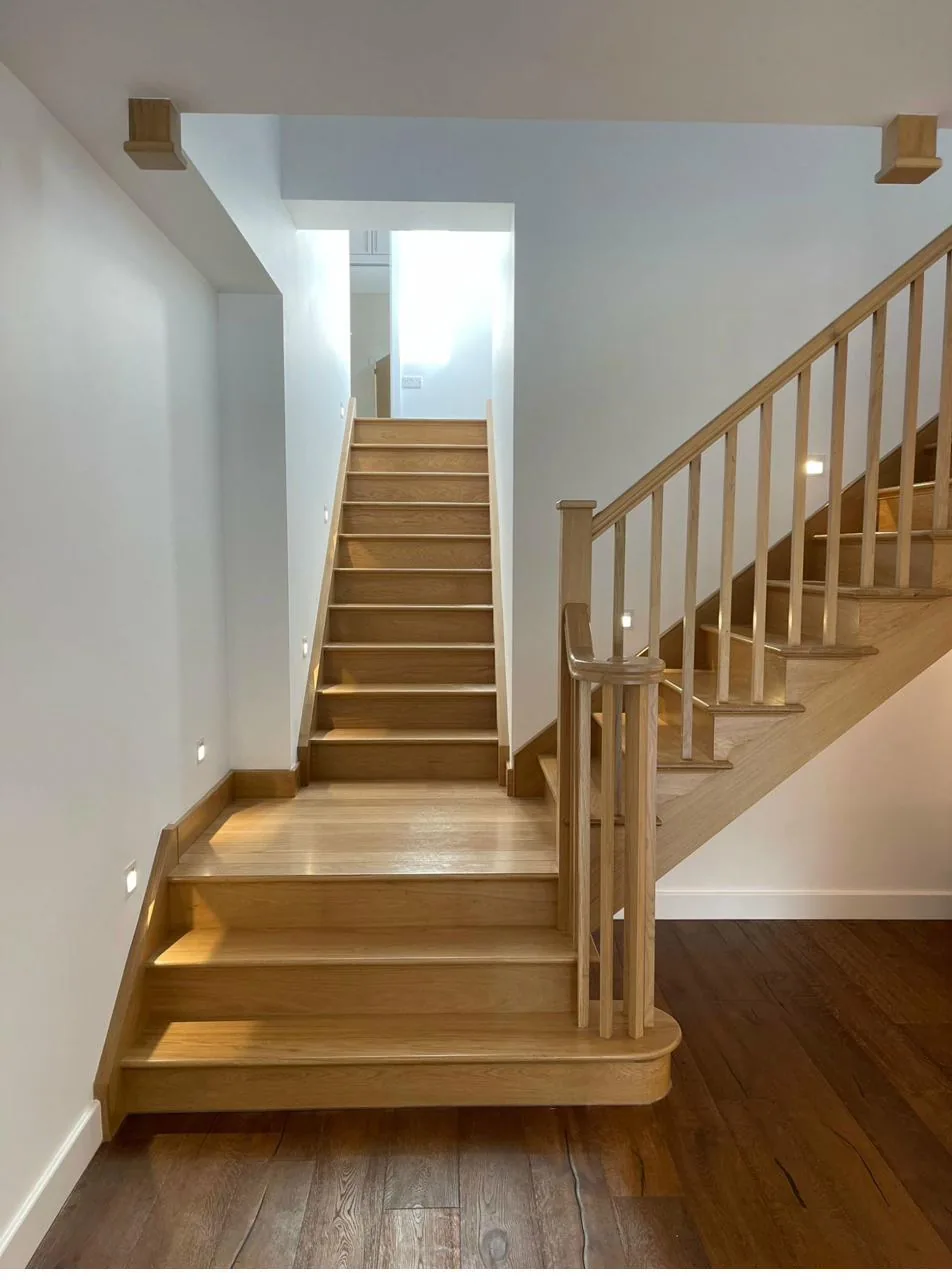 Bespoke oak staircase with curved bullnose starting tread and traditional balustrade